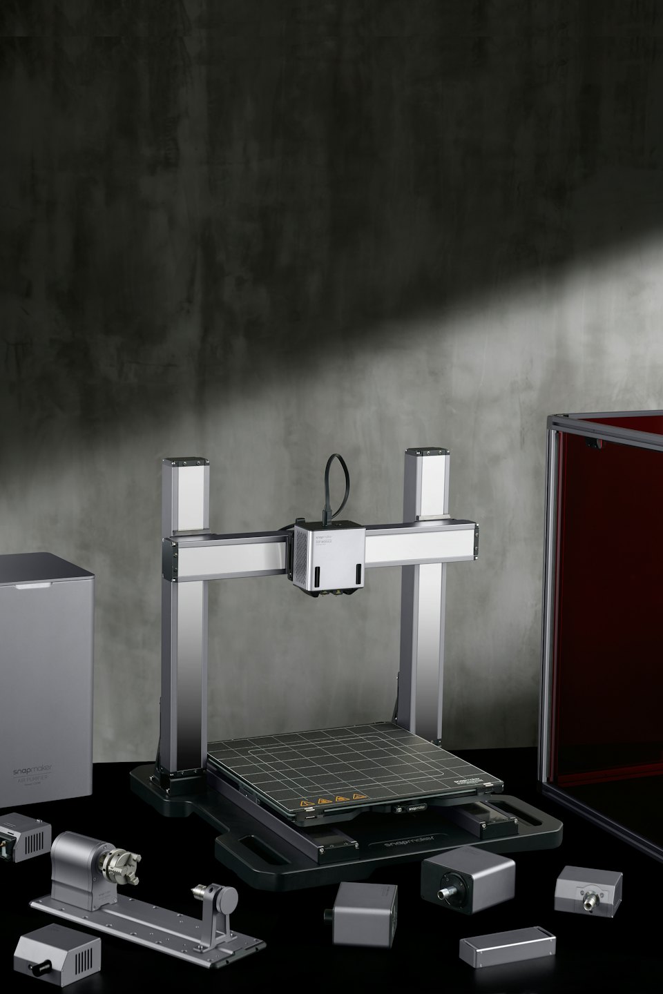 Modular 3D printer and CNC machine with tools on a reflective surface.