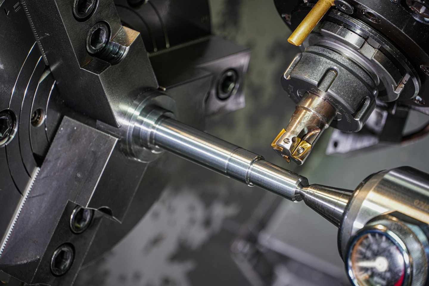 CNC machine shaping a silver metal bar with a cutting tool.